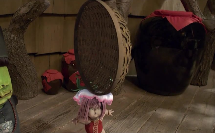 A spirit in a tall hat beside a small figure.
