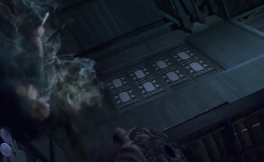 Smoke and a figure inside a wooden hall.