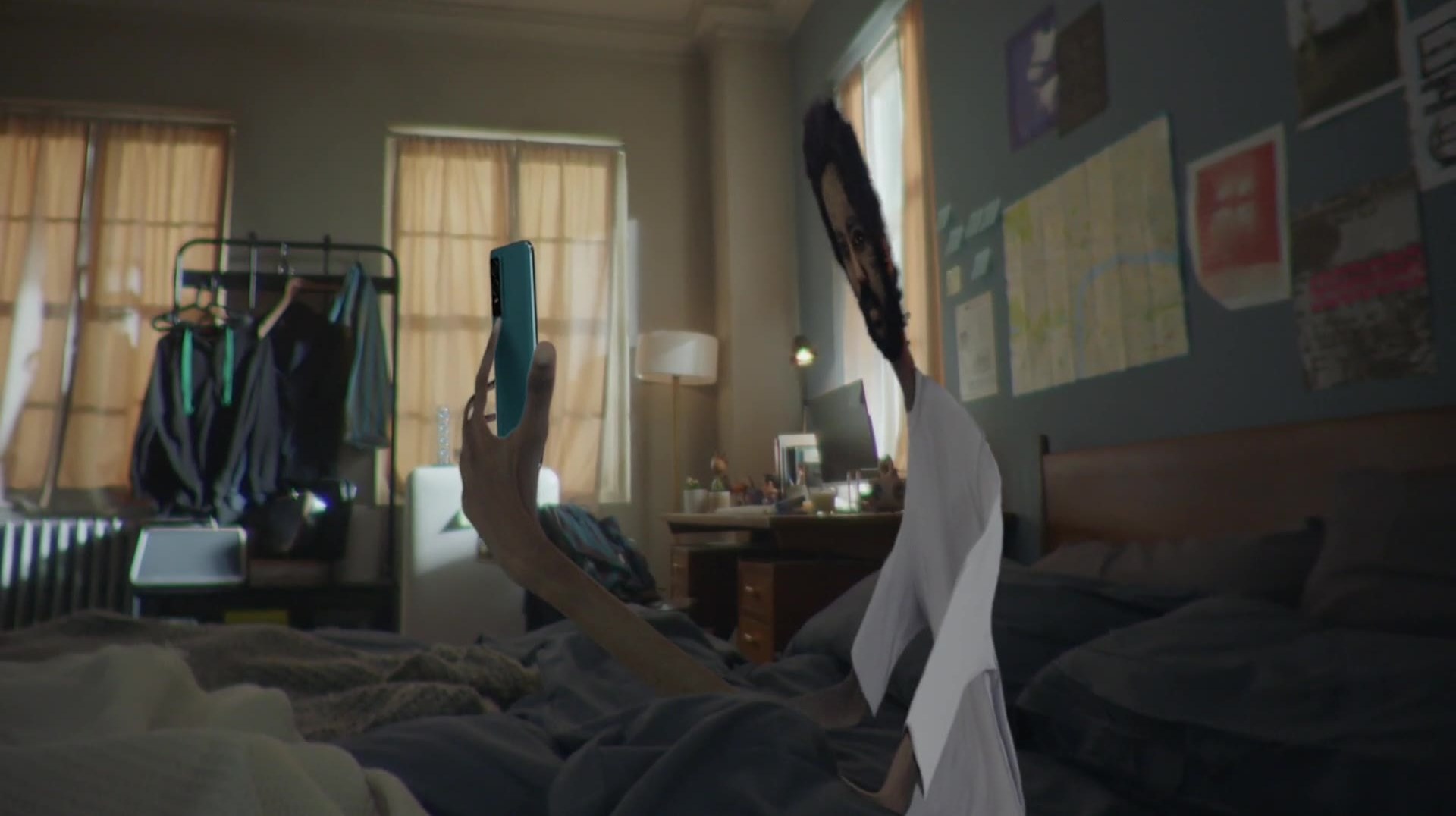 A hand reaching across a bedroom for a phone.